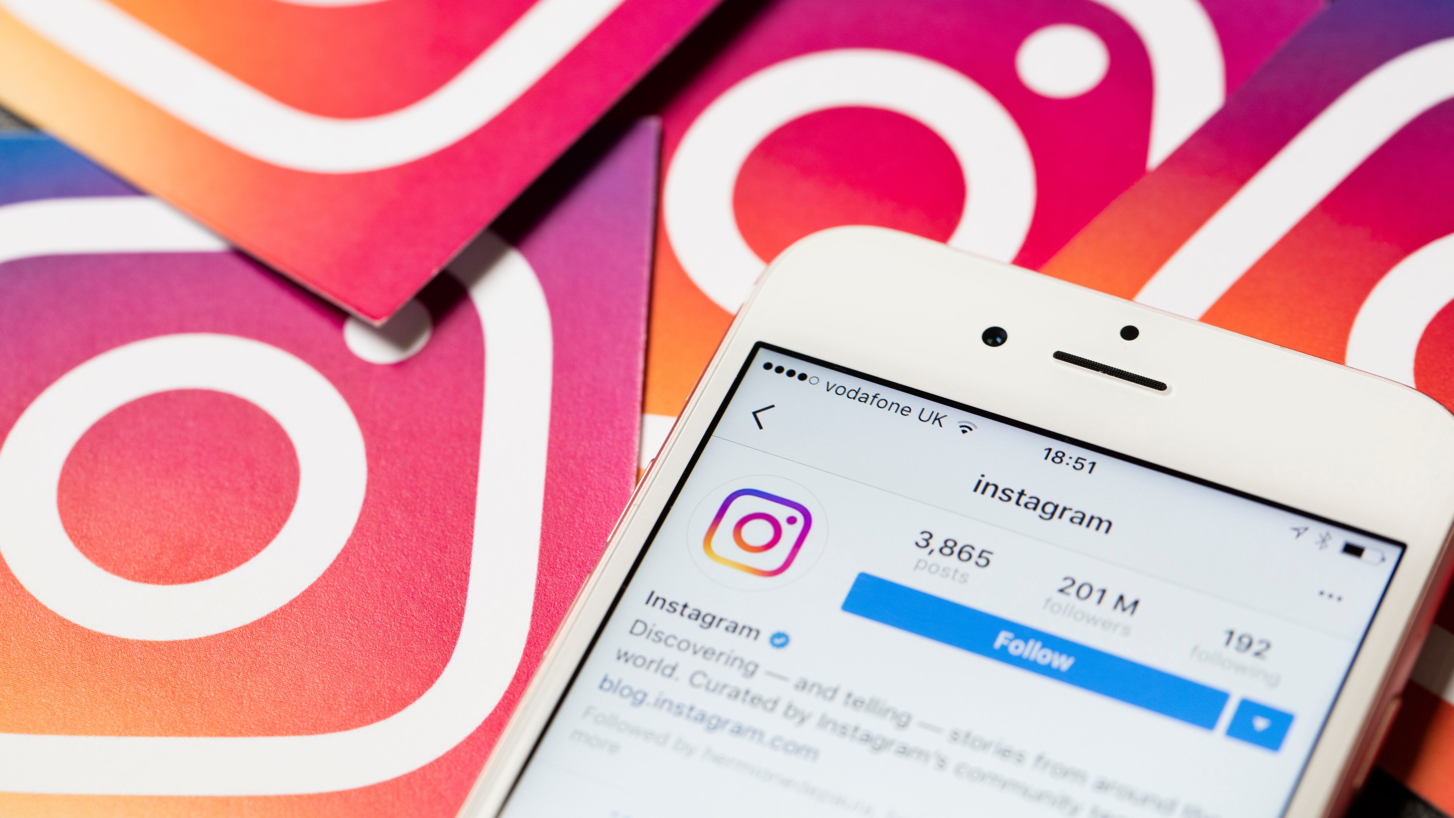 Smartphone shows the Instagram app with Instagram logos